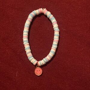 Blue, pink, and white bracelet with smily face charm.
